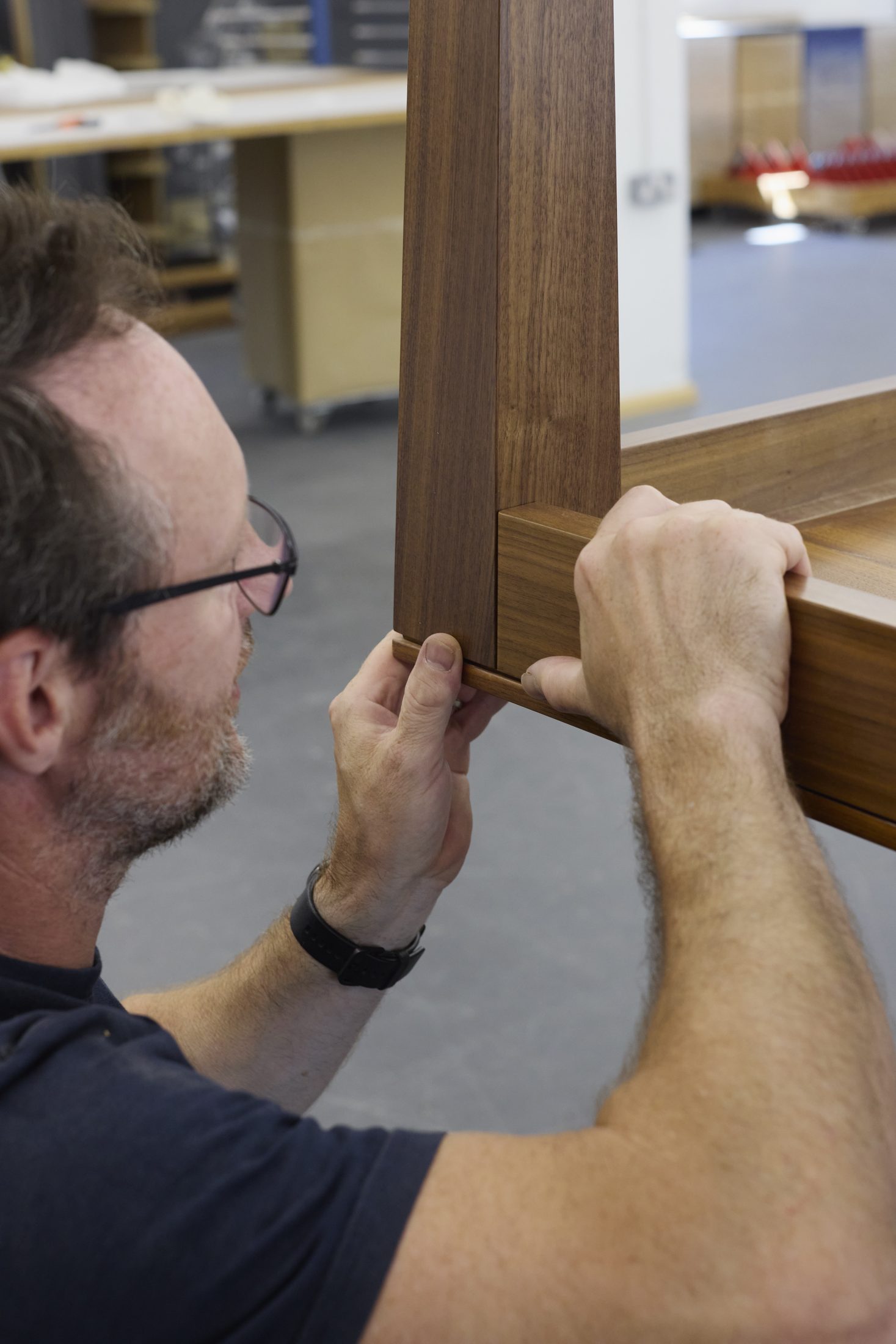 Craftsman fitting a mortise and tenon joint on a table frame
