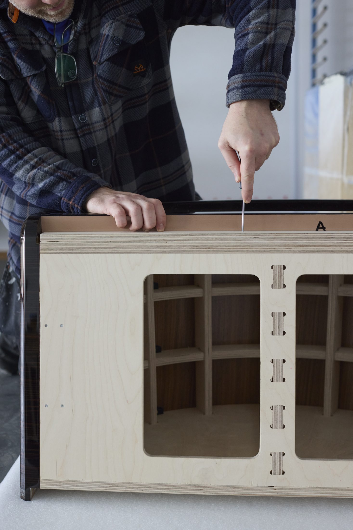 Fitting hardware to a cabinet carcass in the workshop