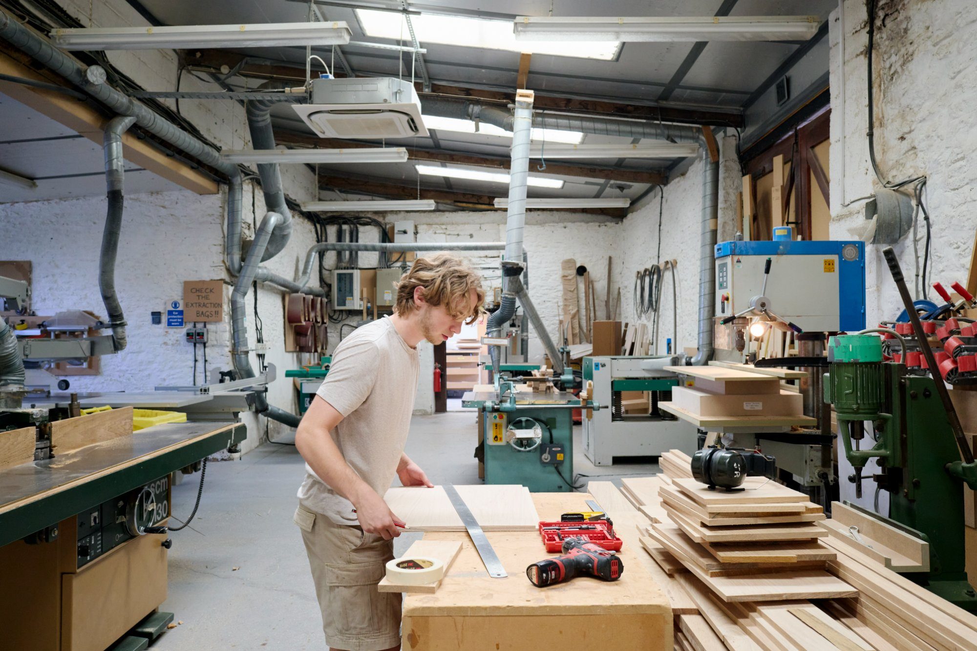 Cabinetmaker measuring timber in the workshop
